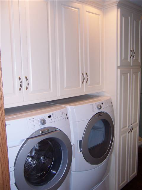 Painted cabinets enclose the washer and dryer